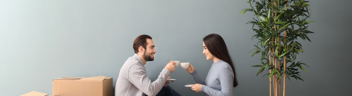 Young couple taking a break from unpacking to drink some tea.